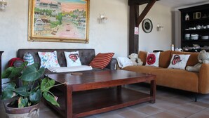 Una sala de estar con un sofá, una mesa de centro y un cuadro grande en la pared.