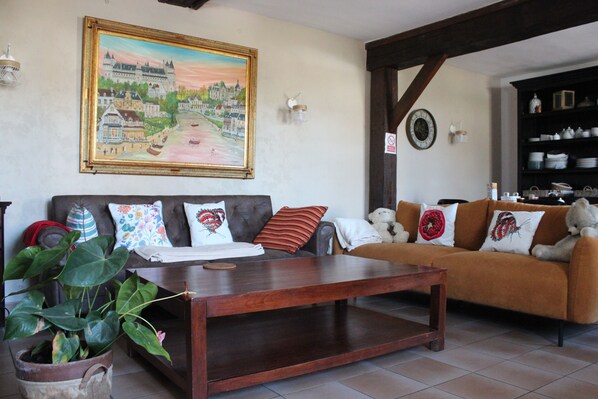 A living room with a sofa, a coffee table, and a large painting on the wall.