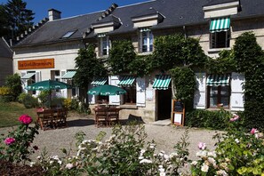A building with outdoor seating and a sign reading "La Gentilhommage".