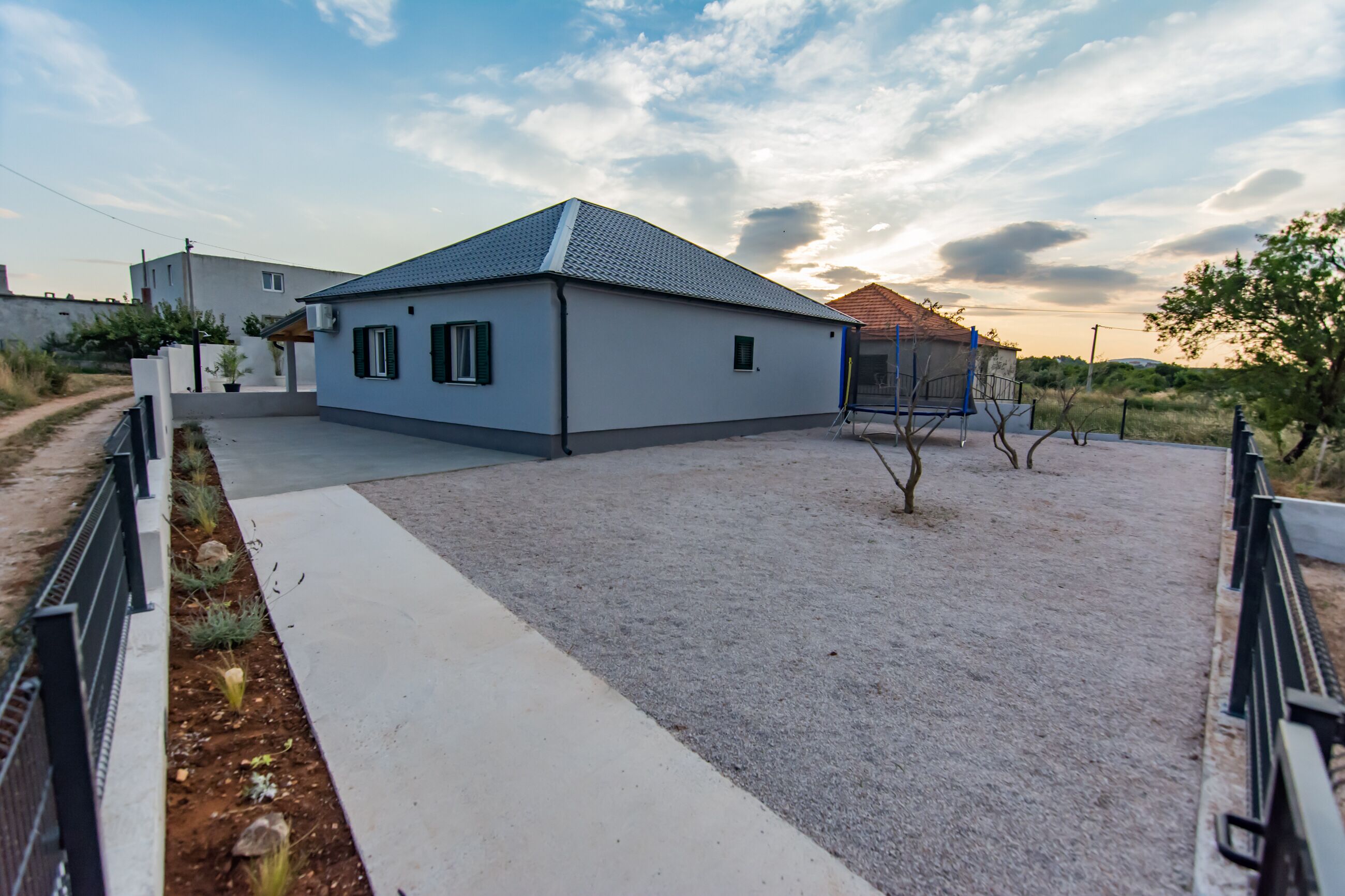 A modern house with a paved driveway and a small garden area.