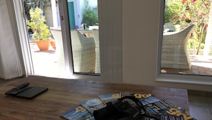 A wooden table with magazines, a camera, and a remote control. - Family-friendly, sunny holiday home with pool, splendid views and solar power (Cape Town)