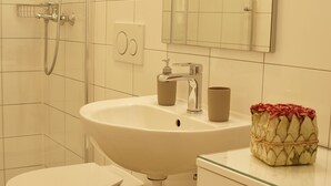 Een badkamer met toilet, wastafel en douche.