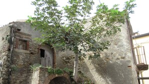 Un edificio antico in pietra con una porta in legno e una piccola finestra.