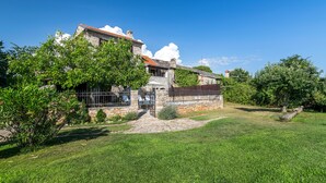 A stone house with a tiled roof, a stone pathway, and a well-maintained lawn. - Istrian villa with swimming pool for an unforgettable holiday  (ZRENJ)