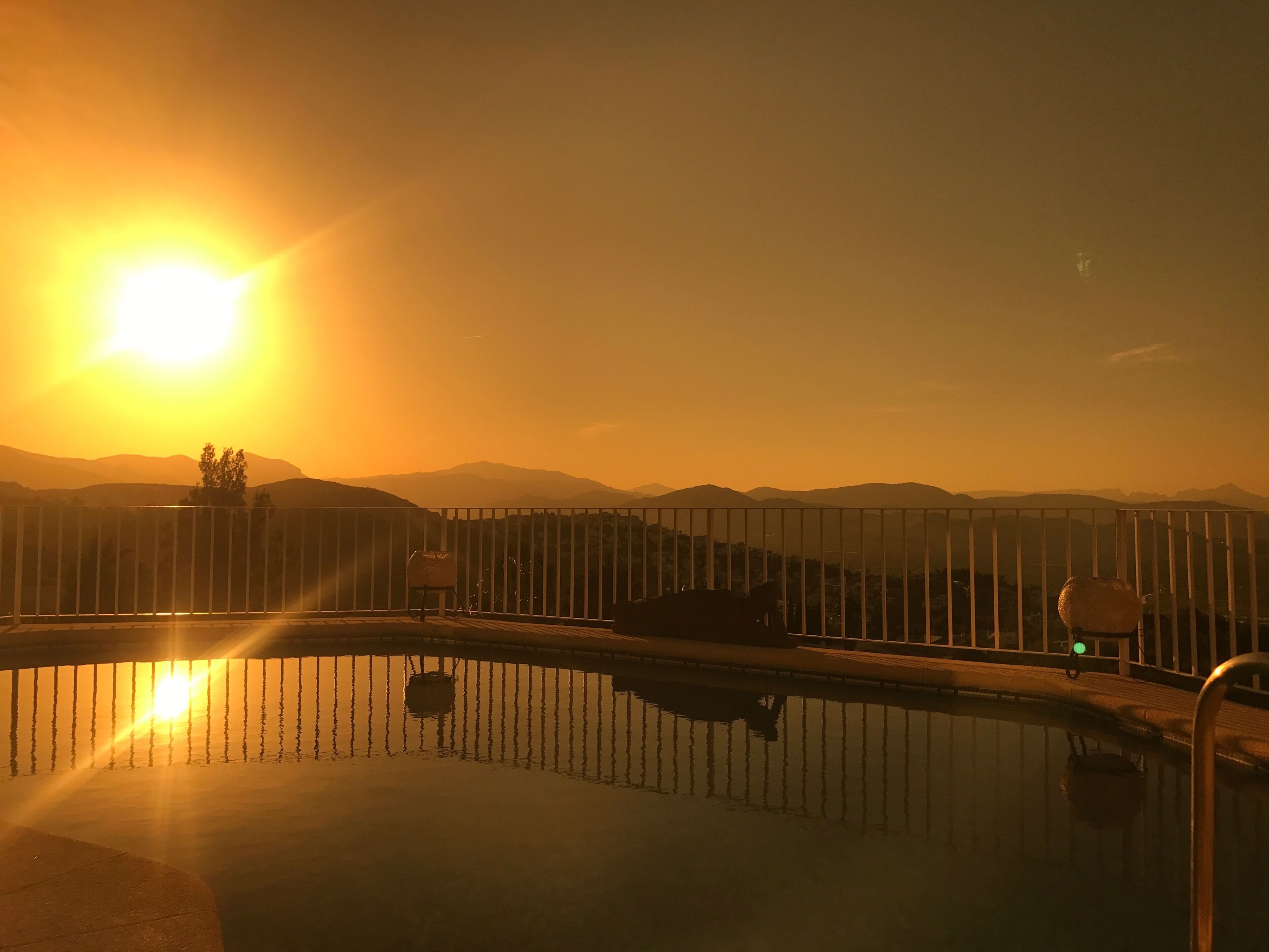 Ein Schwimmbecken mit Blick auf Berge im Abendlicht.