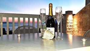 A table with a bottle of champagne, two glasses, and a candle on a balcony overlooking the sea. - Holiday apartment "Villa Bonaca" with a beautiful panoramic (Baska Voda)