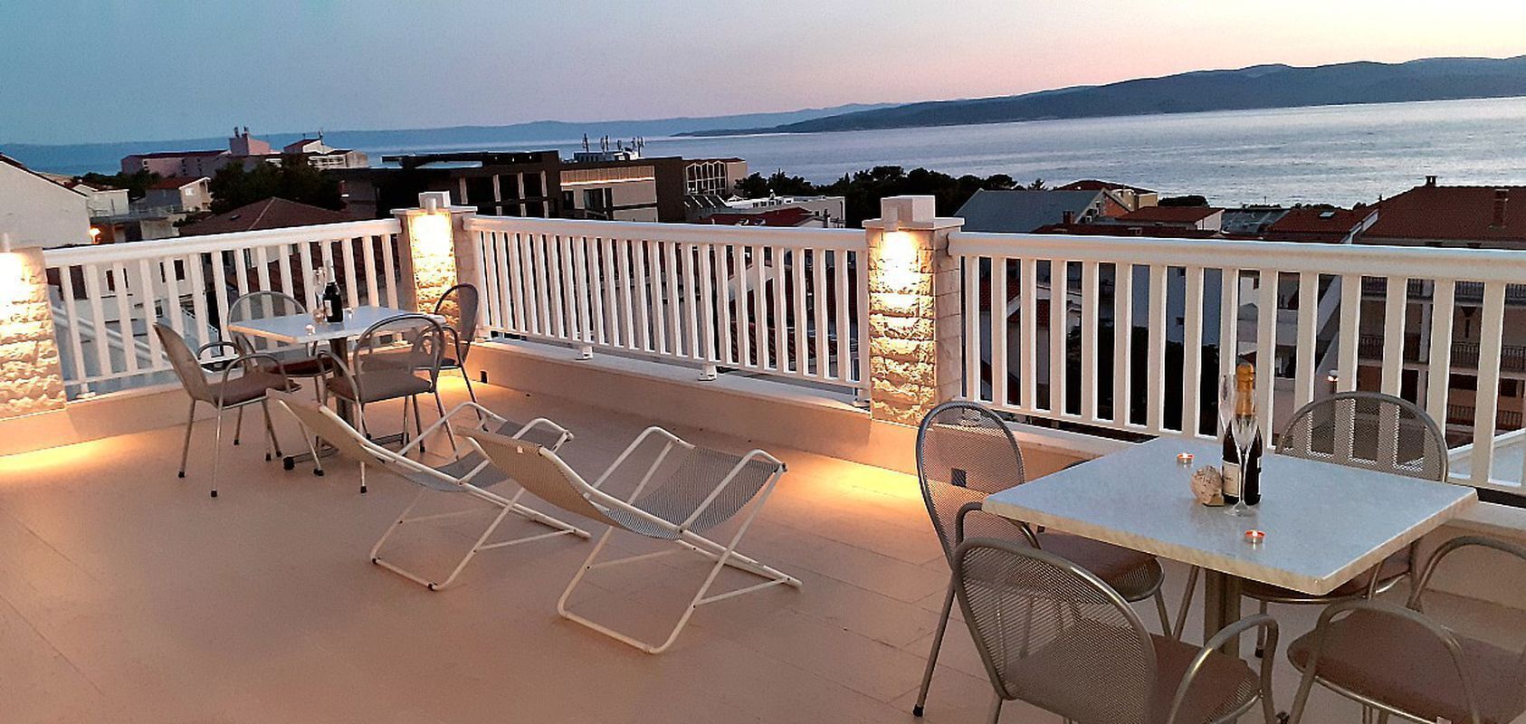 Ein Balkon mit Meerblick, ausgestattet mit einem Tisch und Stühlen sowie einem Geländer.
