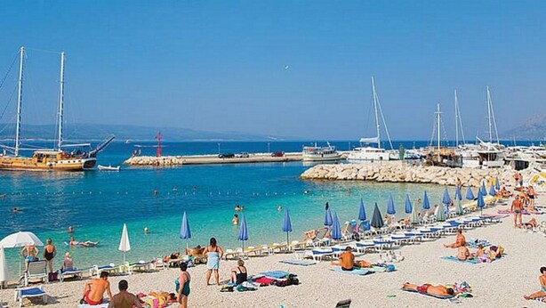 A beach with boats, umbrellas, and people. - Holiday apartment "Villa Bonaca" with a beautiful panoramic (Baska Voda)