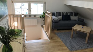 A modern living room with a grey sofa, a small wooden table, and a patterned rug. - Wendlers Ferienwohnungen 4-6 (Schwaig bei Nuernberg)