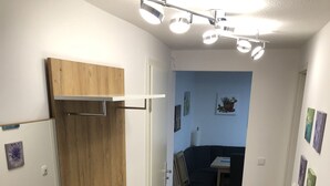 A modern kitchen with wooden cabinets, a white countertop, and a built-in oven. - Wendlers Ferienwohnungen 4-6 (Schwaig bei Nuernberg)