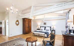 A spacious bedroom with a large bed, a wooden wardrobe, a chandelier, and a classic chair. - Suite Olivier, Château Gassies, charm 15 minutes from Bordeaux, up to 4 guests (Latresne)