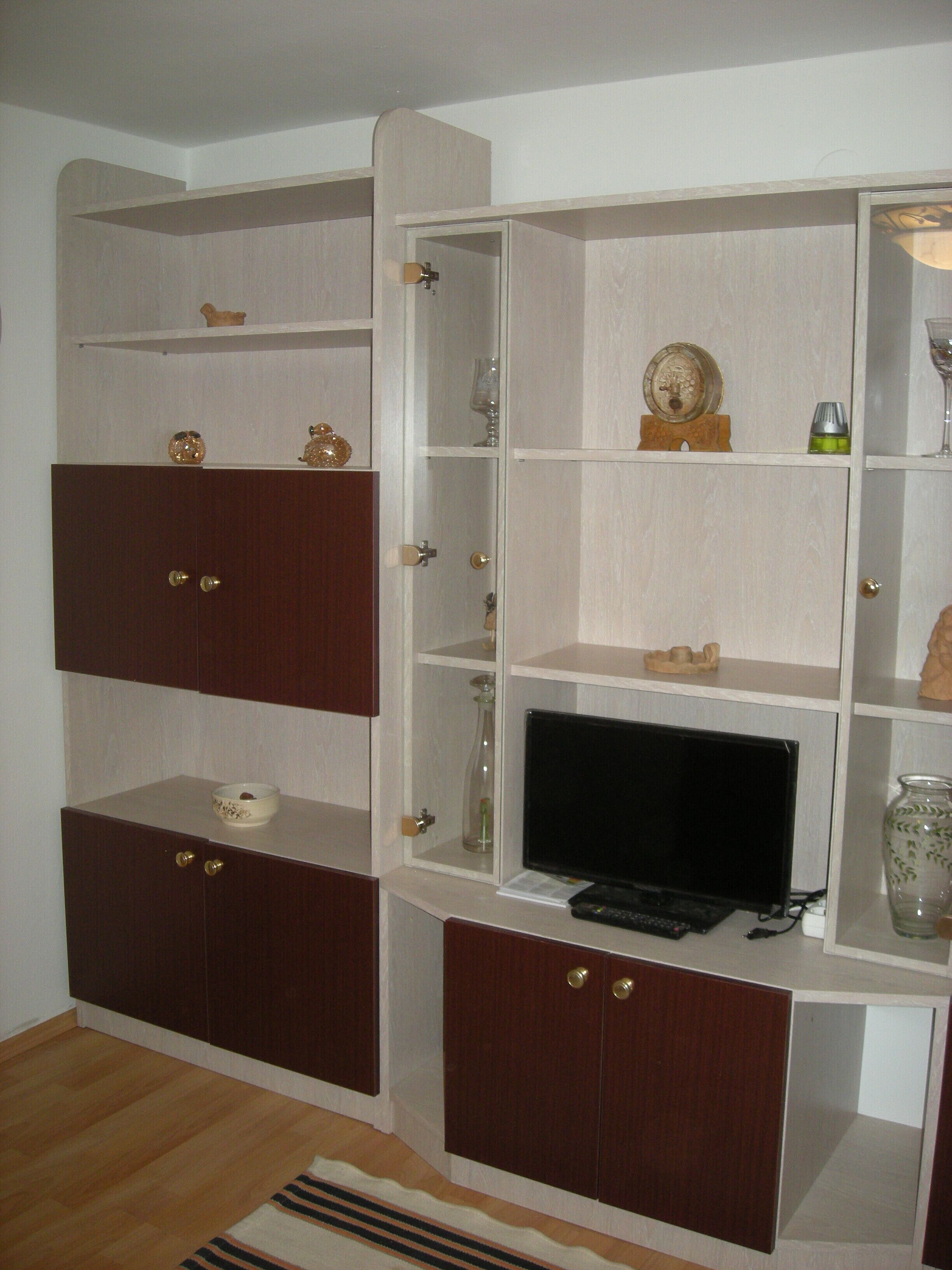 Een kamer met een houten kast, een televisie en diverse decoratieve objecten.