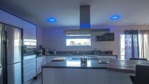 Una cocina moderna con una isla central, electrodomésticos de acero inoxidable e iluminación empotrada.