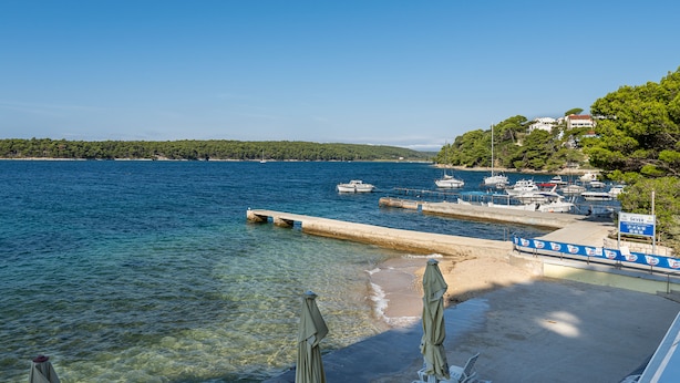 A marina with boats docked, a sandy beach, and lounge chairs with umbrellas. - APARTMENT 67 M2 - A BEDROOM, MODERN, COMFORTABLE LARGE BALCONY, BATH VIEW (Palit)