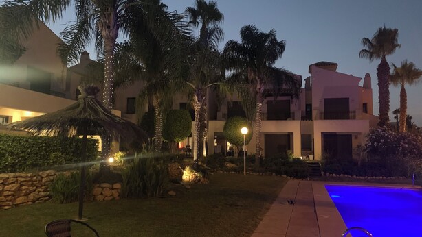 A resort with a swimming pool, palm trees, and a thatched-roof structure. - Very nice house with terrace and pool (Roda)