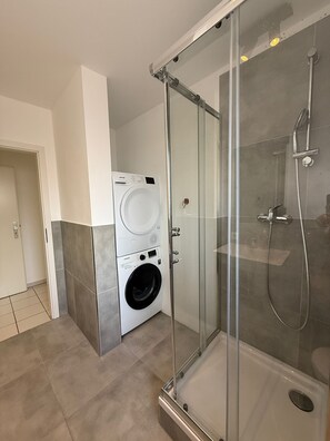 Een bad/douchecombinatie, handdoeken