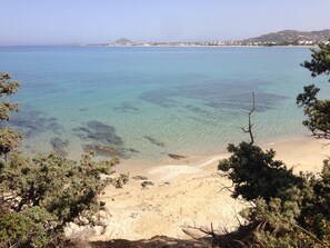 A coastal beach with clear water, sandy shore, and surrounding vegetation. - Naxos Beachvilla, a dreamhouse, 60m to sandy beach, big garden, top location (Naxos Town)