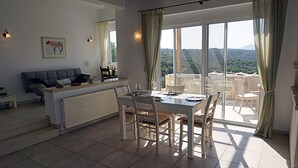 A dining area with a table set for four, a sofa, and a radiator.