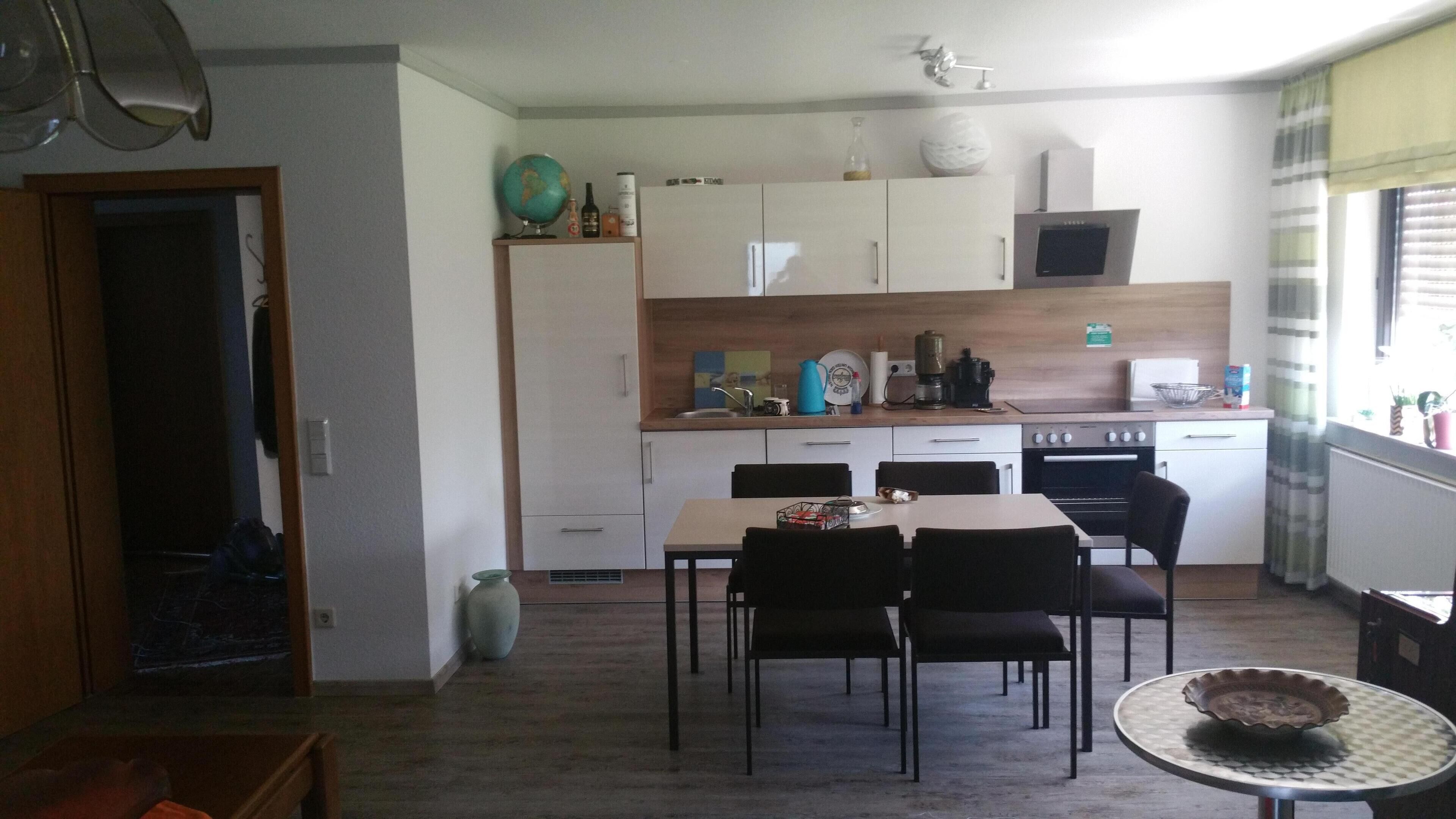 Cocina compacta con comedor, que incluye una mesa, sillas, microondas y estufa.