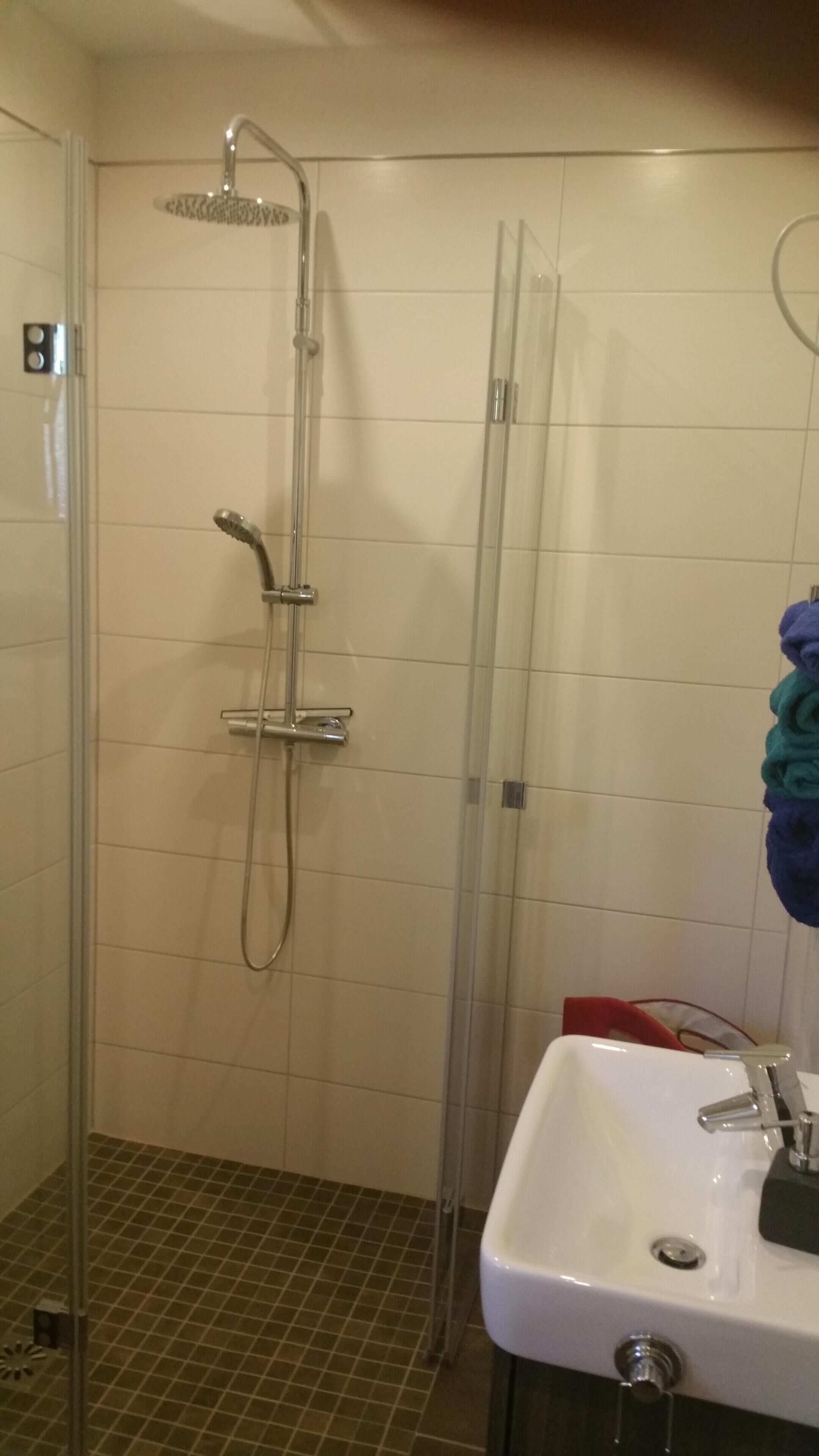 Une salle de bain avec une douche, un lavabo et un miroir.