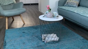 En modern lägenhet i loftstil med en mysig sittgrupp, ett kök i bakgrunden och ett takfönster.