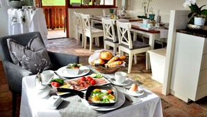 Un comedor con una mesa dispuesta para el desayuno, incluyendo pan, huevos y verduras.