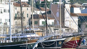 En lysthavn med flere sejlbåde i havnen, omgivet af bygninger i traditionel arkitektur.