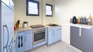 A modern kitchen with a built-in oven, a coffee maker, and a coffee station. - Apartment with pool on the Cote Azur (Bagnols en foret)
