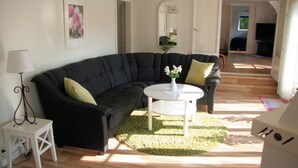 A living room with a dark sofa, a white coffee table, and a green rug.