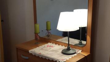 A wooden dresser with a mirror and a lamp.
