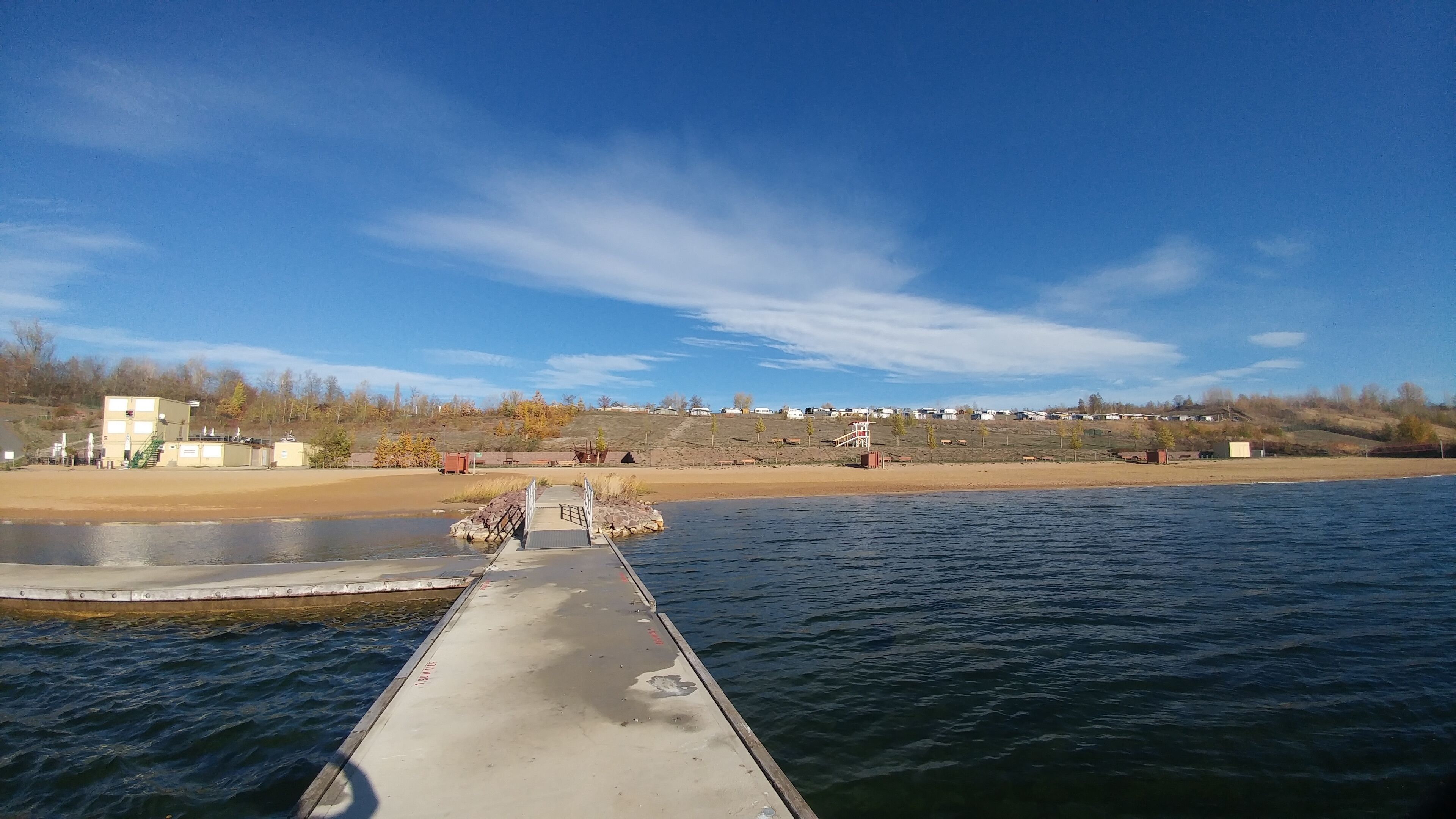 A dock extending into a body of water with a clear sky above.