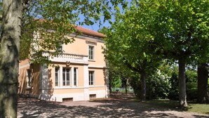 Un bâtiment à la façade symétrique, doté de grandes fenêtres et d’une entrée centrale.