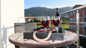 A round table with a mosaic top, two glasses of red wine, a bottle, and a basket of cherries. - SPECIAL OFFER! Studio APARTMENT with BALCONY (Kaštel Stari)
