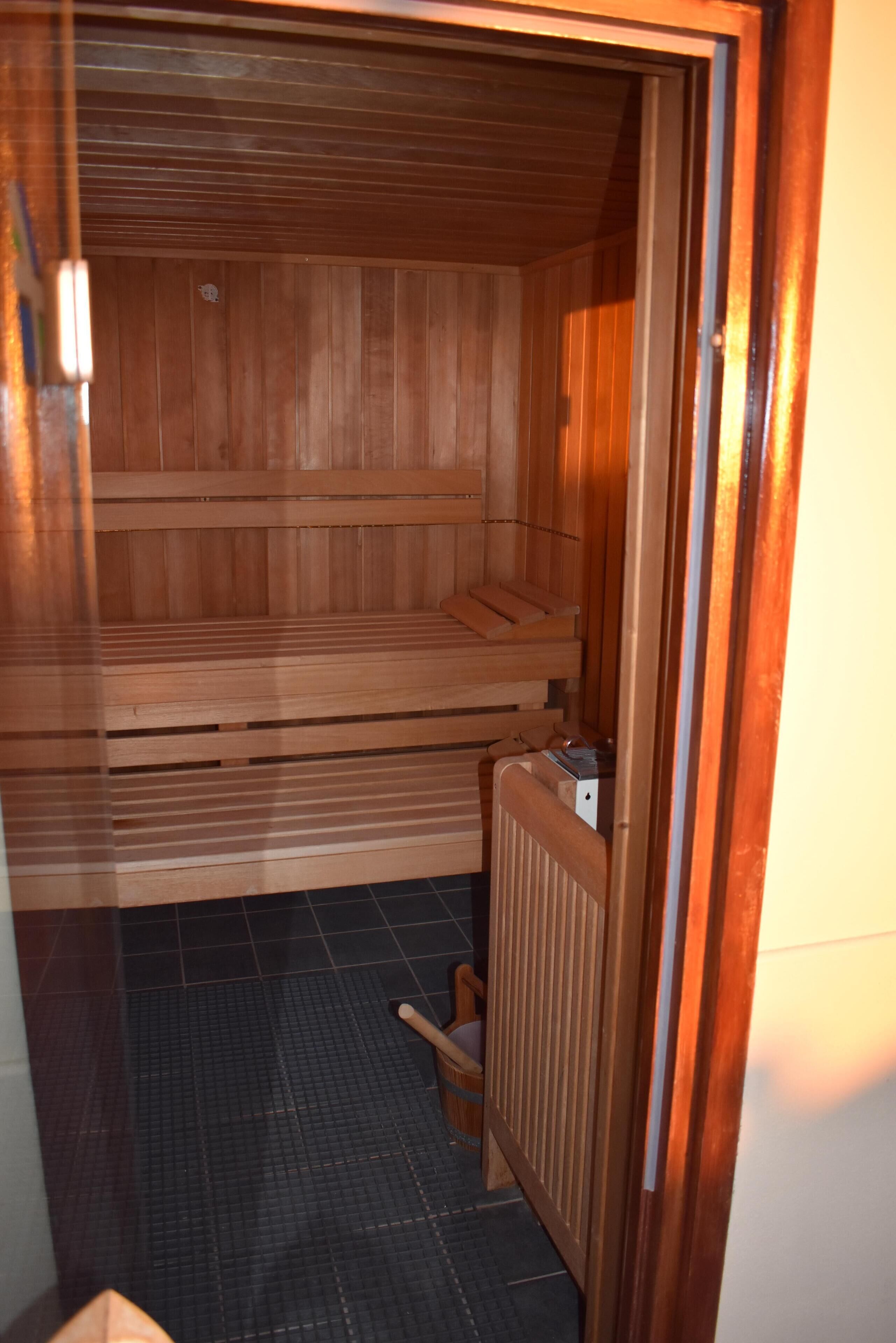 A sauna with wooden benches and a tiled floor.