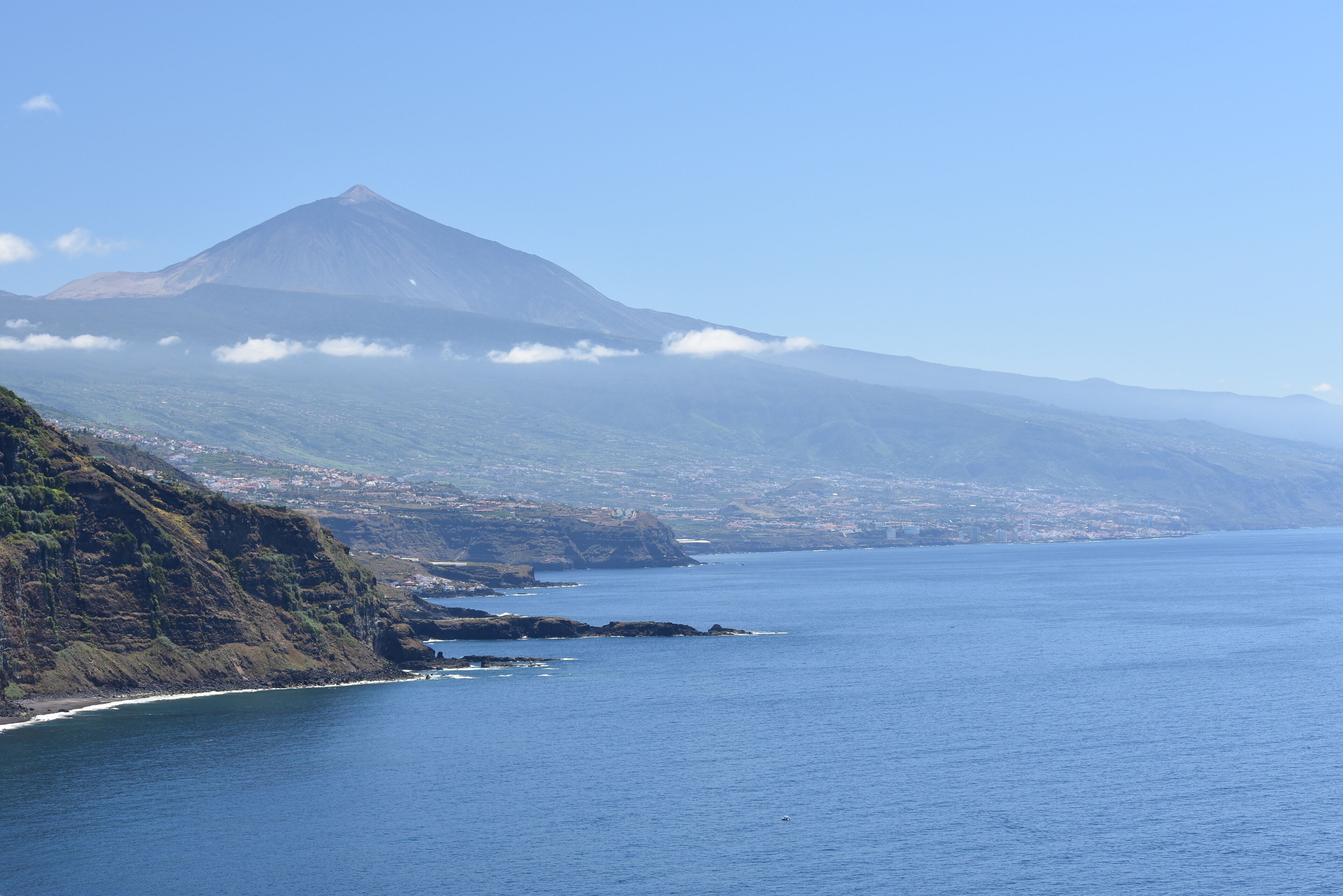 A coastal landscape with a mountain and a clear view of the sea.