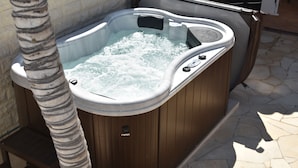 Ein Whirlpool mit Holzverkleidung und einer integrierten Sitzbank.