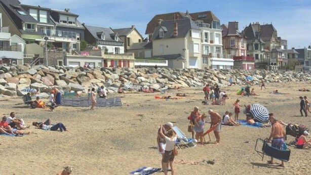 A beach with people sunbathing and swimming, and houses in the background. - Charming village house, Mt St Michel Bay (Genêts)