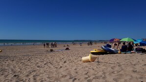 A sandy beach with people, umbrellas, and inflatable rafts. - Gîte "le Marité", 4 people (Sartilly)
