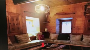 Ein gemütliches Wohnzimmer mit einer Holzsofa, einem Couchtisch und einer Pendelleuchte.
