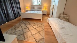 A bedroom with a bed, bedside tables, a window, and a wardrobe.