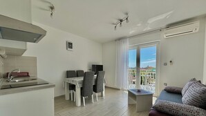 A modern apartment with a kitchen, dining area, and balcony.