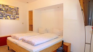 Una cama individual con estructura de madera y una mesita de noche pequeña.