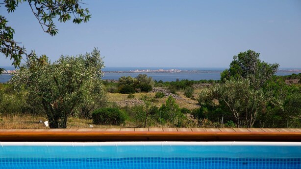Una piscina con vista sul mare e sul verde circostante.