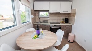 A compact kitchen with a dining table set for two, a window, and a view of the outside. - Holiday home in Pula,2 km from the amphitheater,family-friendly,quietly,WIFI (Pula)