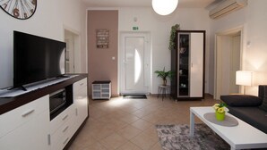 A modern hotel lobby with a flat-screen TV, a reception desk, a seating area, and a large clock on the wall. - Holiday home in Pula,2 km from the amphitheater,family-friendly,quietly,WIFI (Pula)