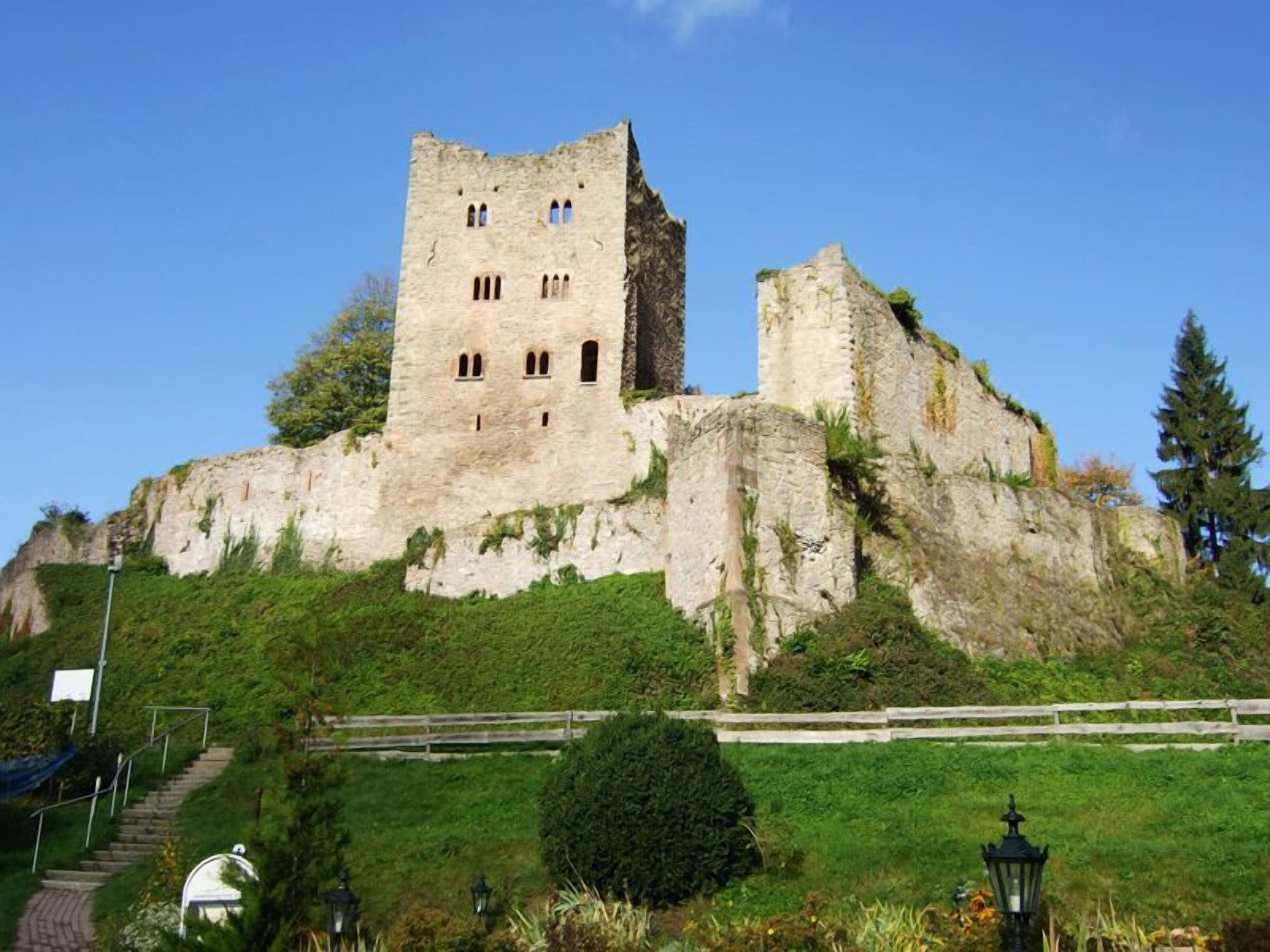 Un castillo de piedra histórico en una colina, con una escalera que conduce hasta él.