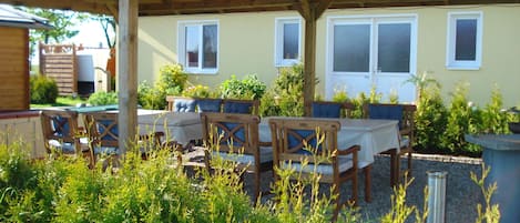 An outdoor patio with wooden furniture and a covered area.
