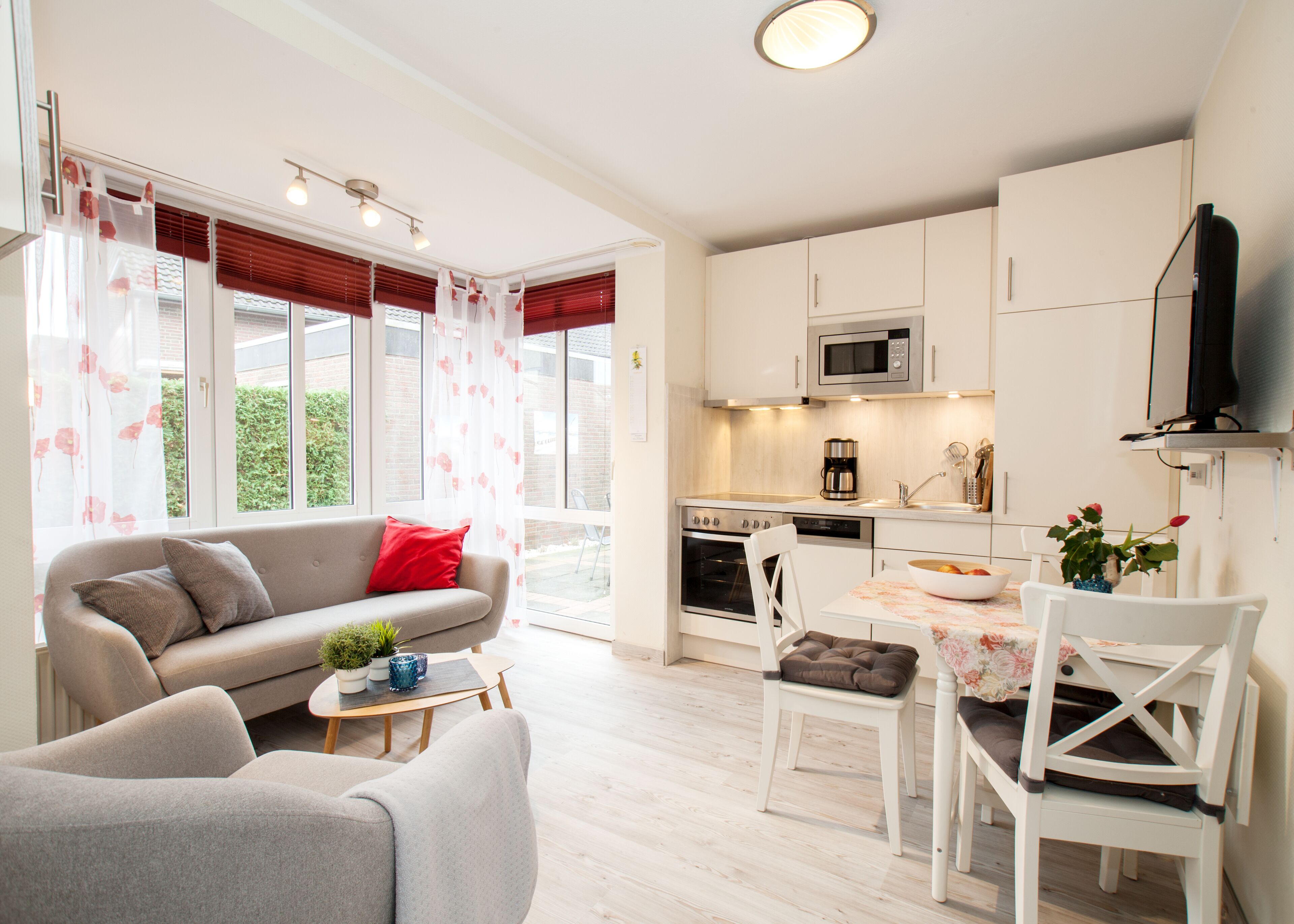 A modern apartment with a living room, dining area, and kitchen.