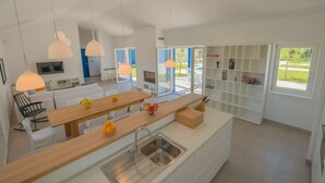 A modern kitchen with a wooden island, white cabinetry, and pendant lighting. - 3000sqm plot, with 50 sqm heated pool, jacuzzi, 2 tennis courts  (Marčana)