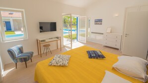A bedroom with a bed, a desk, a chair, a TV, and a view of a swimming pool. - 3000sqm plot, with 50 sqm heated pool, jacuzzi, 2 tennis courts  (Marčana)